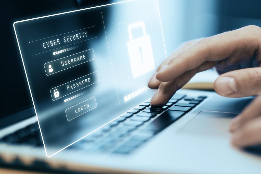 Main tapant sur un clavier d’ordinateur avec affichage holographique d’un écran de connexion sécurisé (username, password, login) – concept de cybersécurité.